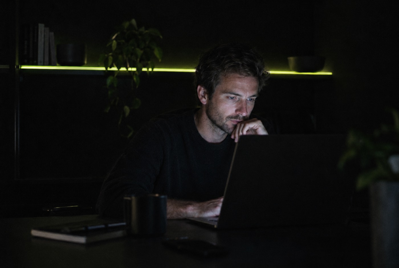 A founder working late at a laptop in a dark room
